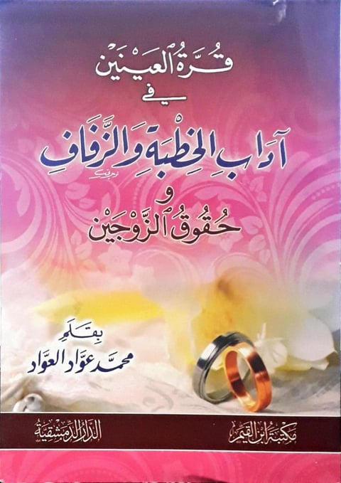 Arabic book cover with pink and yellow gradient background, white and blue text, and two wedding rings at the bottom